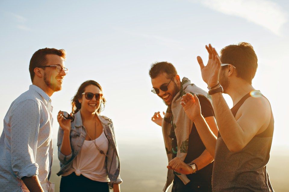 Friends laughing together outdoors in the sunshine